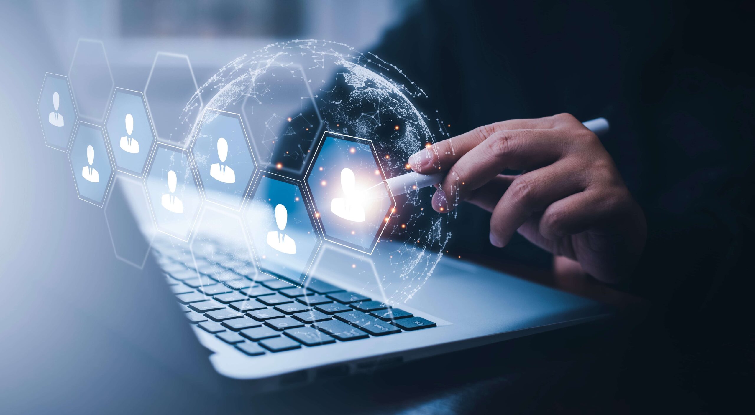 Person interacting with a laptop as a digital globe and user icons appear, illustrating secure access and identity verification in a connected network.