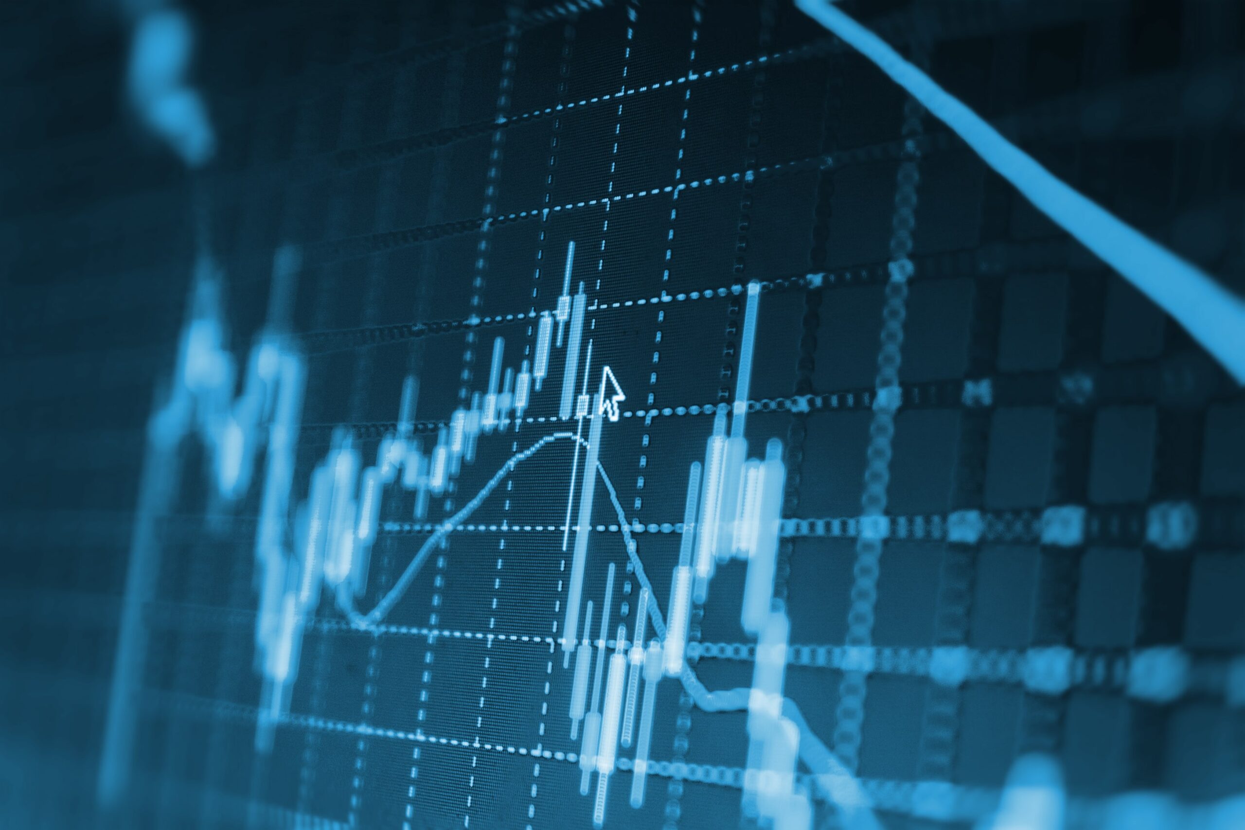 Close-up of a digital stock chart showing fluctuating financial data with line graphs and a blue-toned grid.
