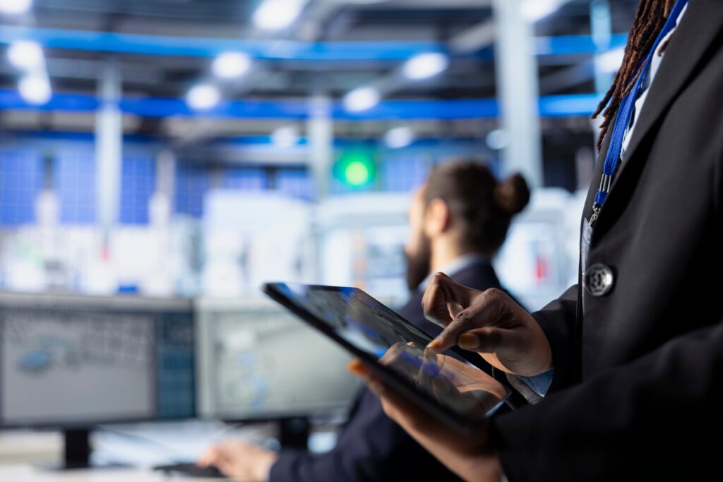 Cybersecurity analyst monitoring systems on a tablet in a security operations center.